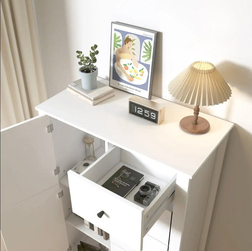 White cabinet with open drawer showing a camera and office items inside