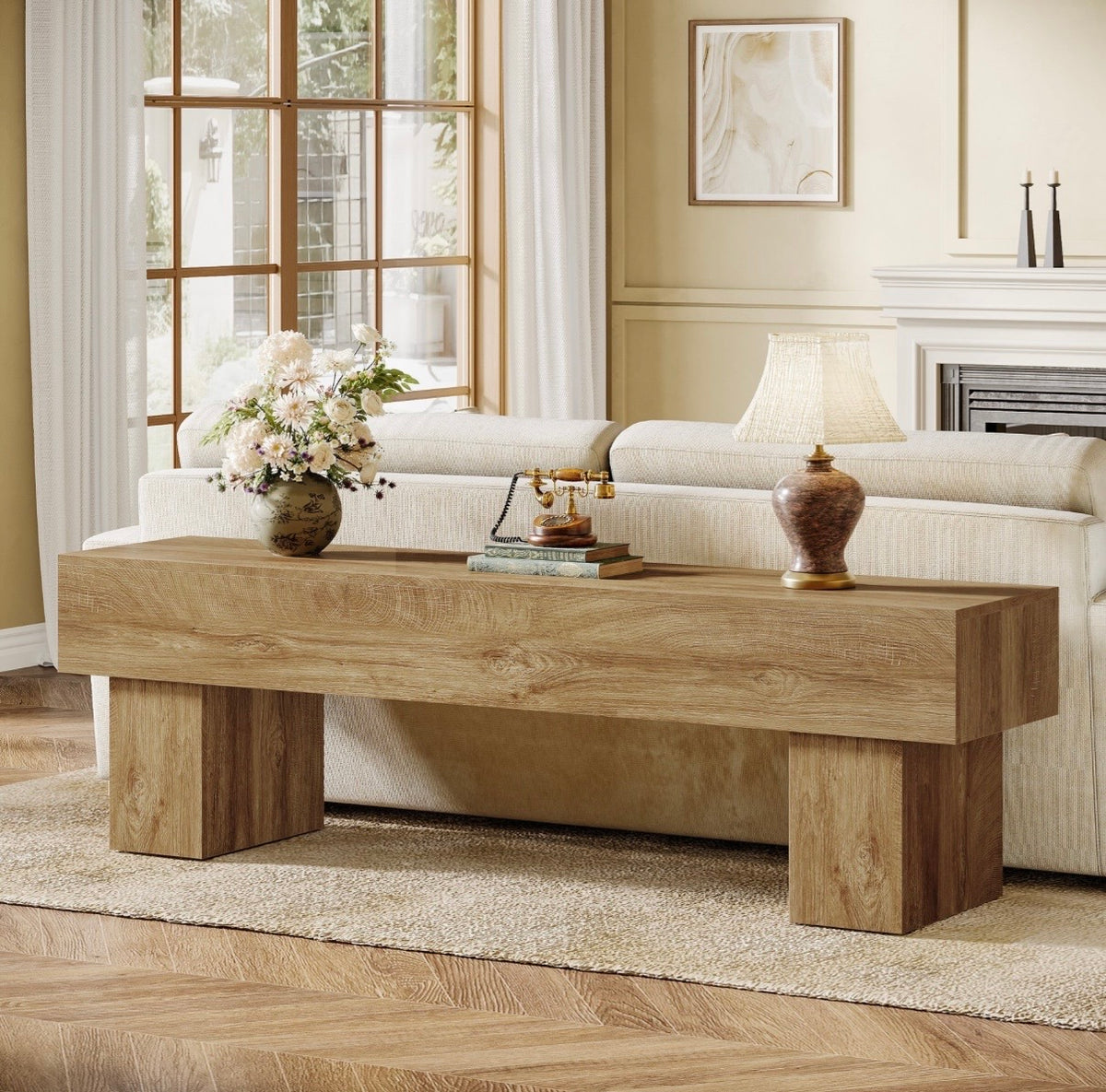 Light oak TV console table with wide top and sturdy block legs beneath framed TV